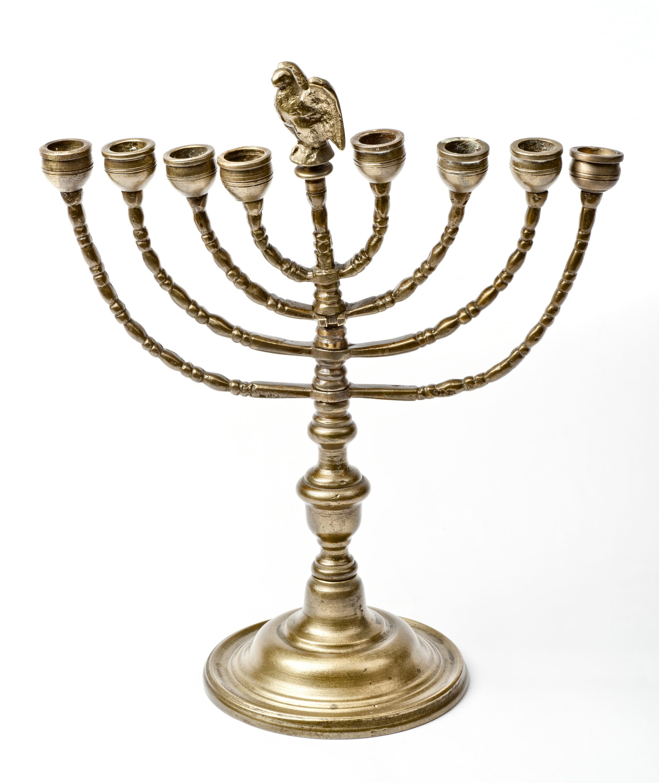 A seven-branched metal menorah with a decorative eagle on the central candlestick, set on a circular base.