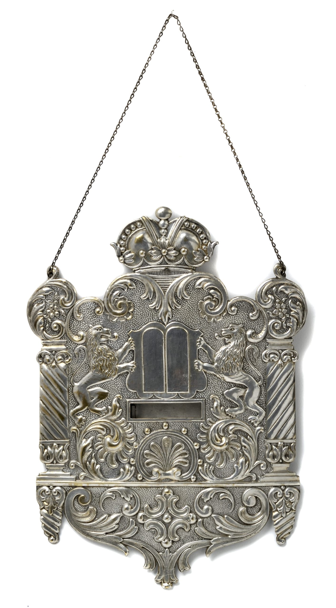 Srebrna tablica o bogatym zdobieniu z motywami lwów, koroną i tablicami Dekalogu, zawieszona na łańcuszku.