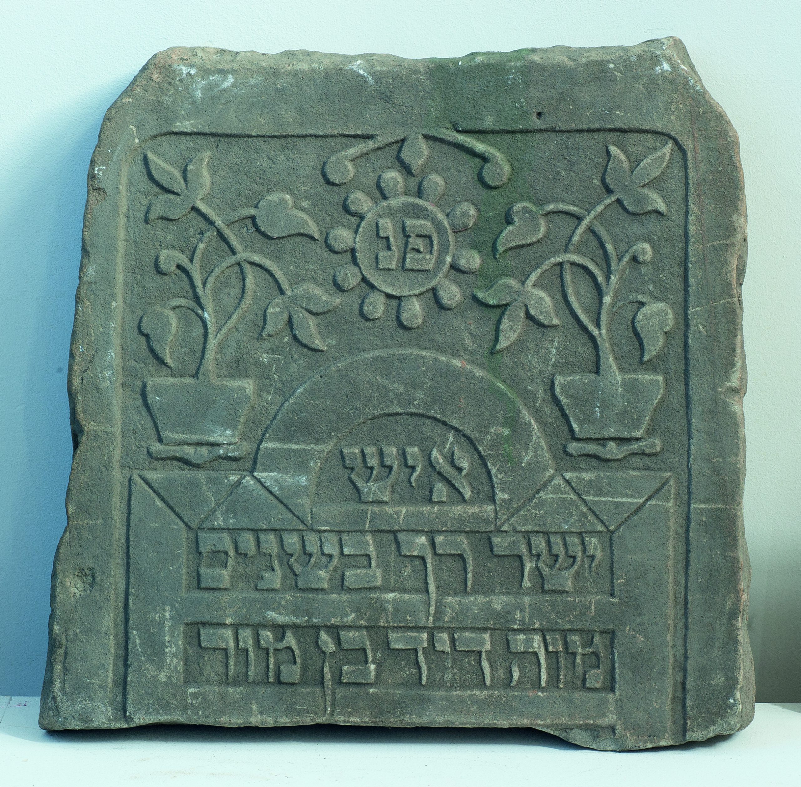 Jewish tombstone with Hebrew inscription and plant motifs.