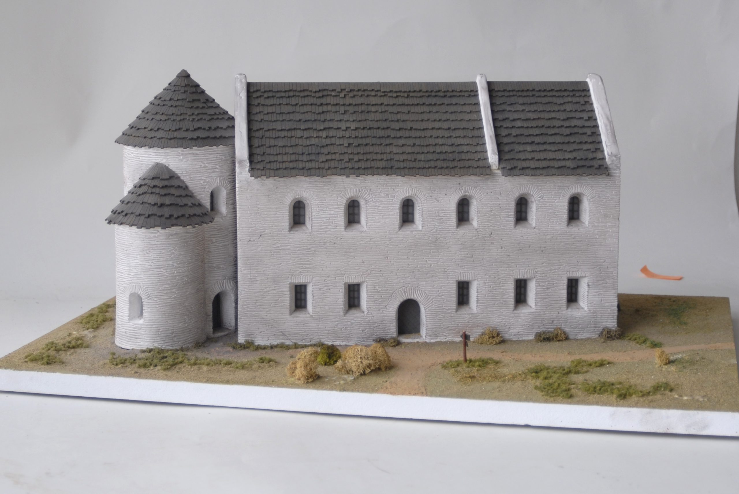 Model of a Romanesque building with towers and a gable roof.