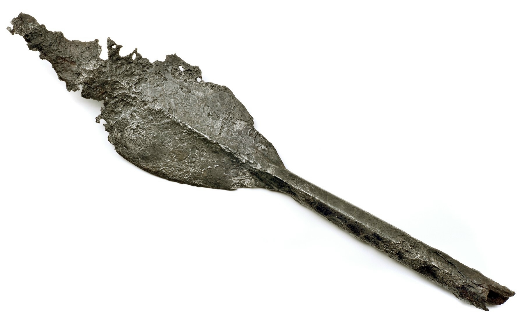 A rusty, damaged, leaf-shaped spearhead made of iron.