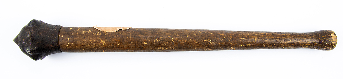 A mace with a wooden handle and a six-pronged metal head, used as a blunt weapon and a symbol of military authority.