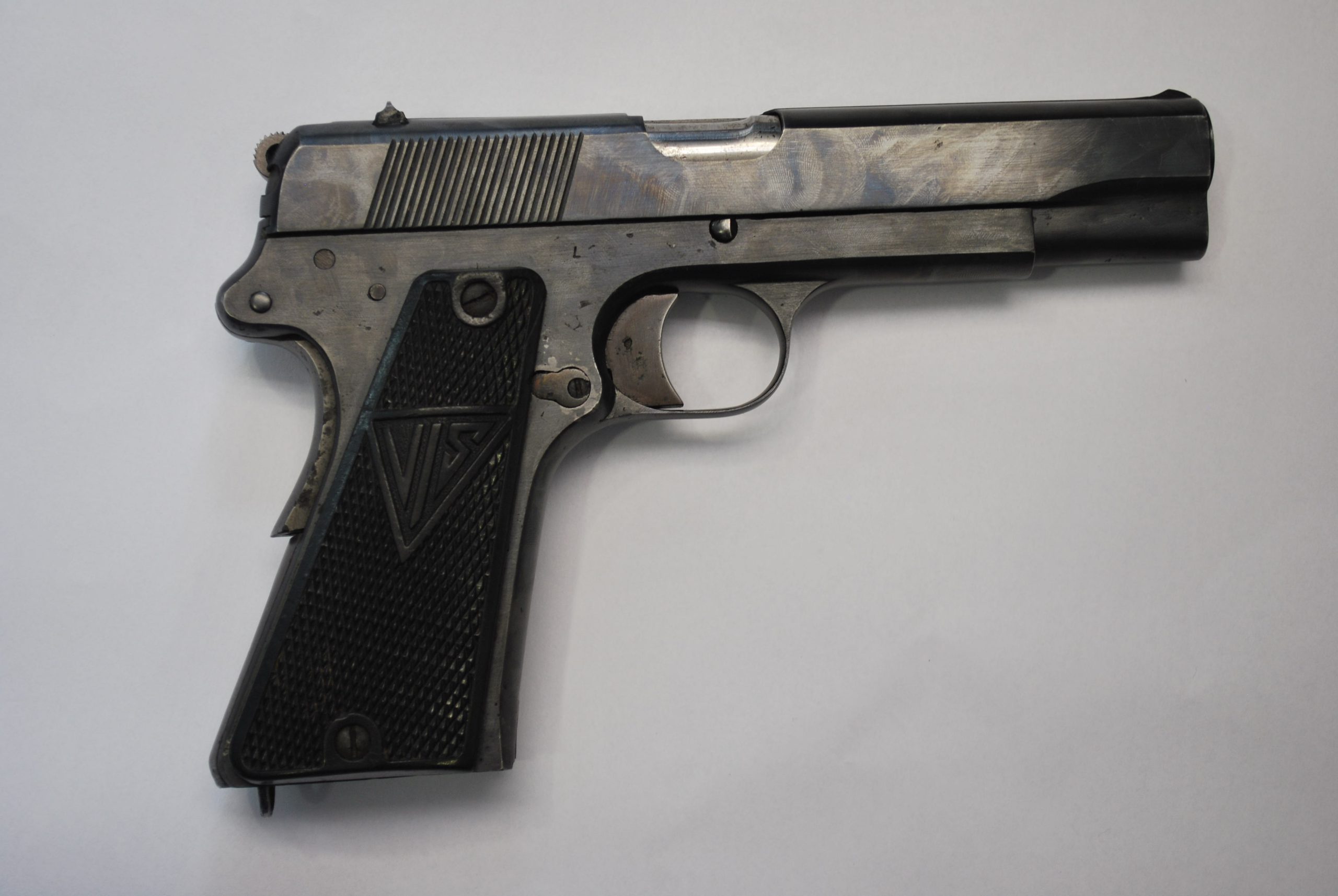 Metal pistol with a black grip and "VIS" engraving.