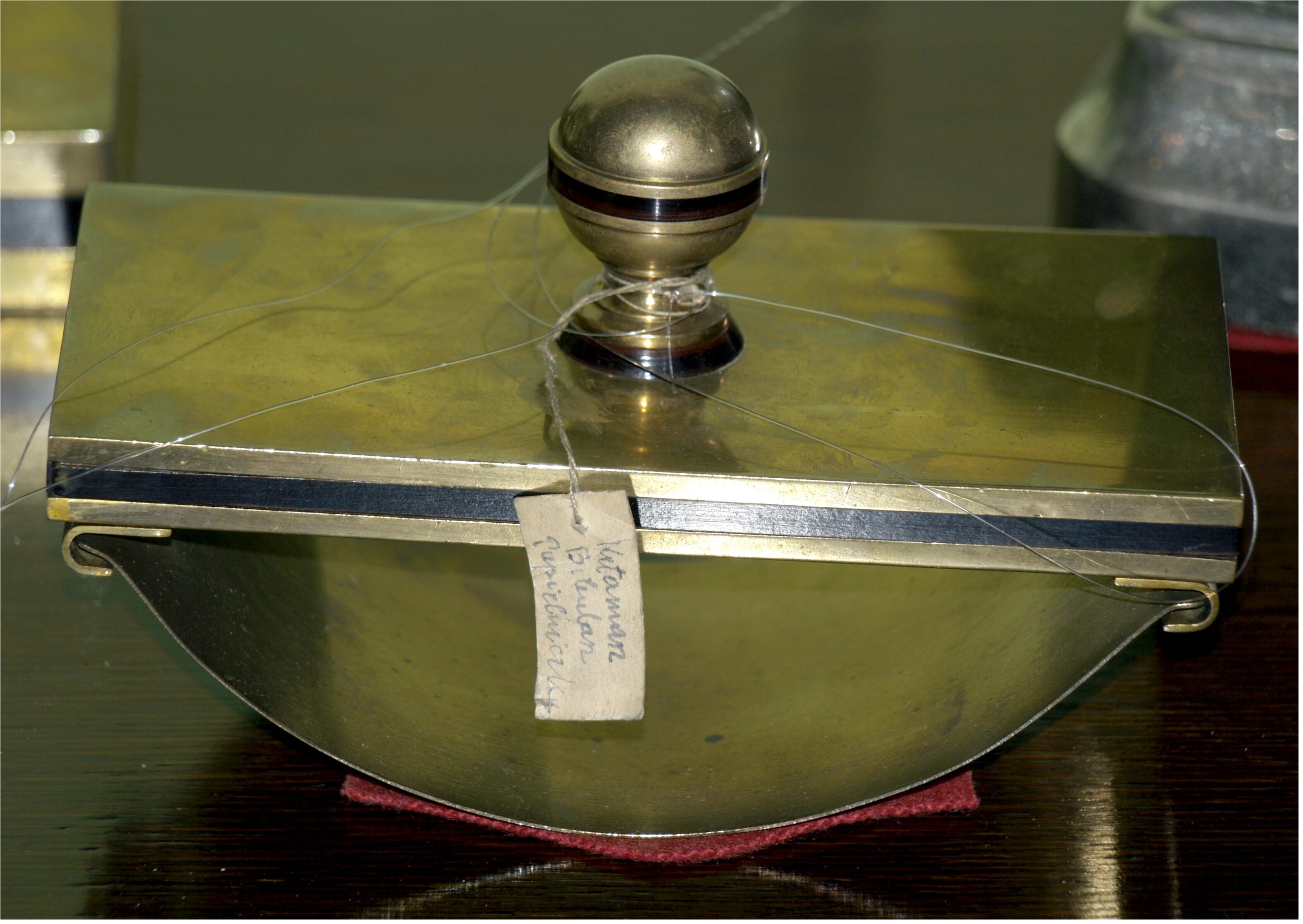 Metal container with a spherical handle.