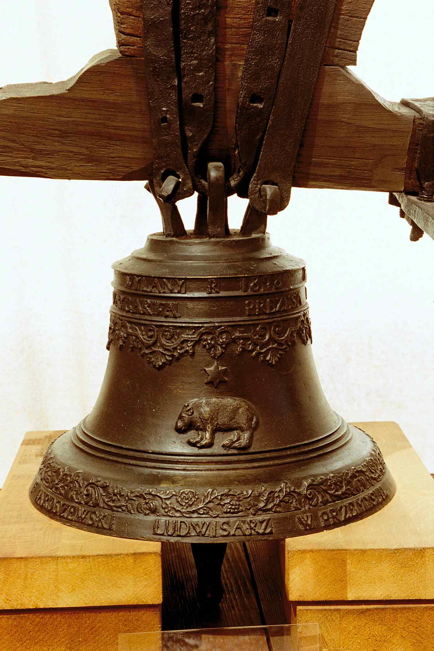 Bronze bell with a relief depicting a bear and decorative inscriptions.