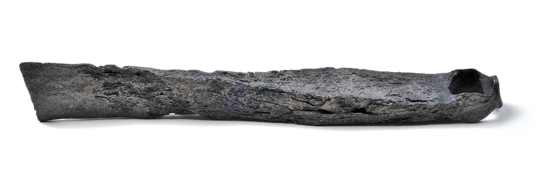 Ancient, heavily corroded iron axe with an irregular surface