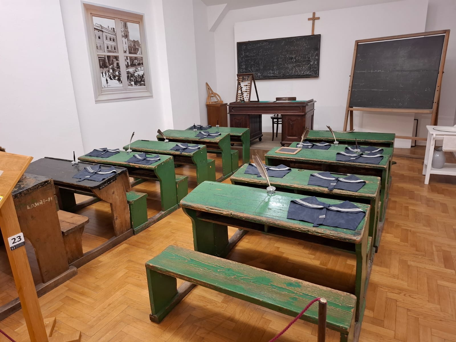Reconstruction of a former classroom with wooden desks, a blackboard, and a teacher's desk.