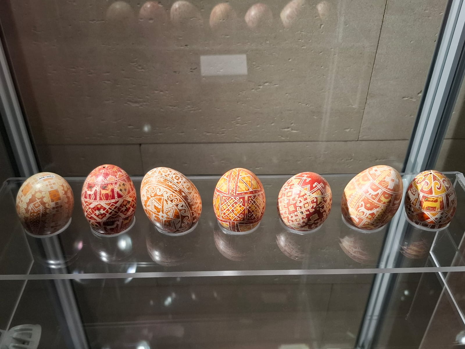 Rząd zdobionych pisanek z tradycyjnymi ornamentami.