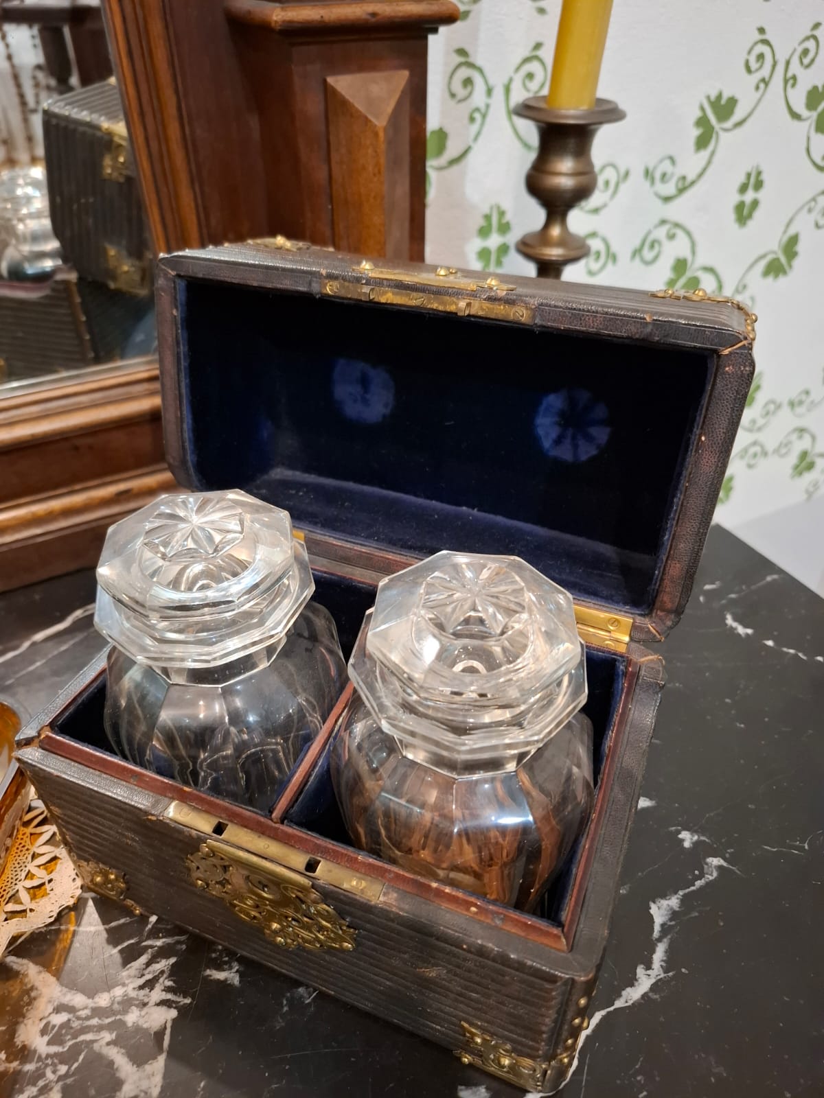 Drewniane pudełko z dwoma szklanymi flakonami, wyściełane aksamitem.